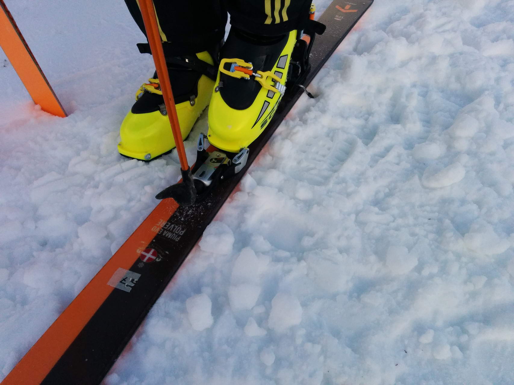 Zum Einstieg in die SKITRAB TR2 muss 1.  mit dem Skistock die Bindung offen gehalten und 2. seitlich der Schuh reingedreht werden.